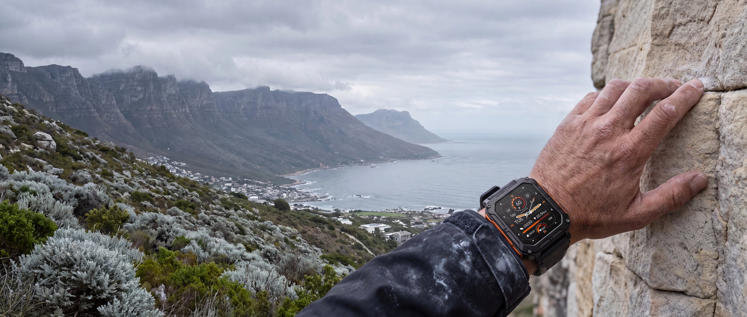 Man wearing the AEGA Nomad rugged smart watch while climbing rocks on the Cape Town coast