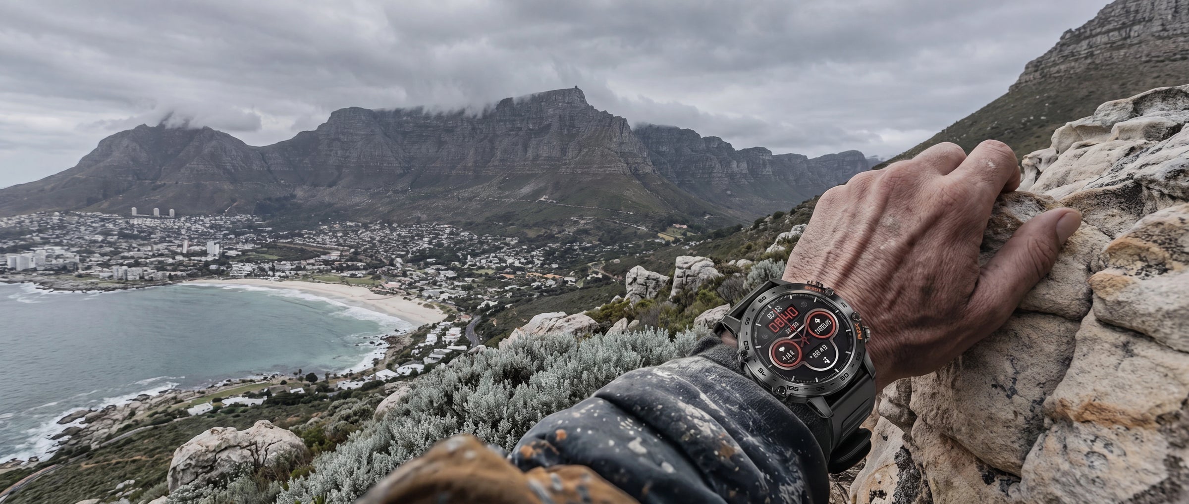 Man wearing the AEGA Nomadic rugged smart watch while climbing rocks on the Cape Town coast